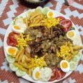 Salade westaf avec du poulet, sauce oignons, crudités présentée dans un grand plat