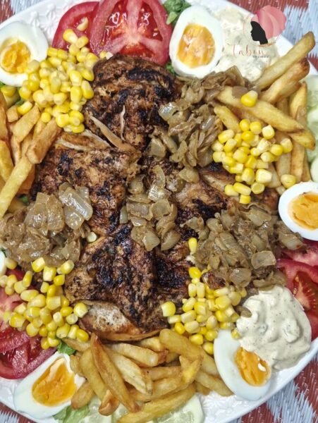 Salade à la sénégalaise, westaf, avec du poulet, tomates, maïs, une sauce mayonnaise et des frites