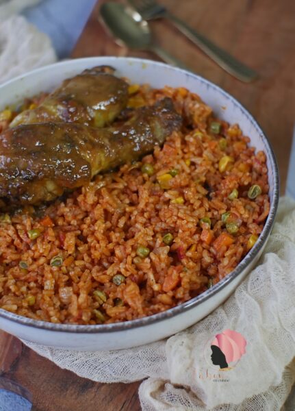 Assiette de jollof rice servi avec une cuisses de poulet dorée au four